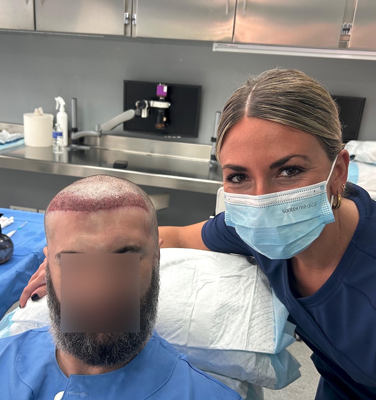 Enfermera especialista con guantes revisando la línea frontal y las entradas de un paciente con injerto capilar FUE inicial en una clínica de Madrid.