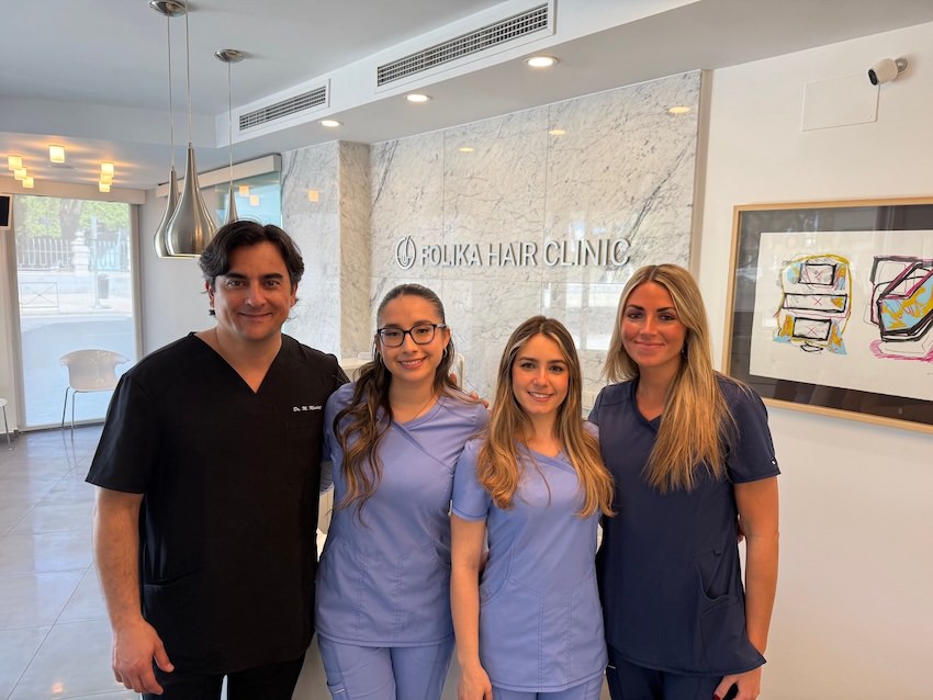 El doctor, la técnico de extracción y las dos enfermeras que forman el equipo médico de Folika Hair Clinic posando en la recepción de su clínica capilar en Madrid.