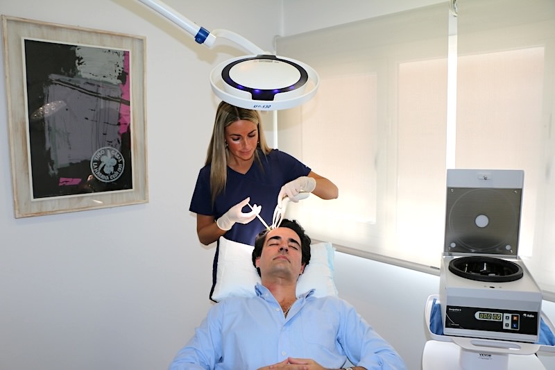 Enfermera especialista de Folika Hair Clinic aplicando un tratamiento de mesoterapia capilar mediante microinyecciones indoloras a un paciente relajado en su clínica de Madrid.